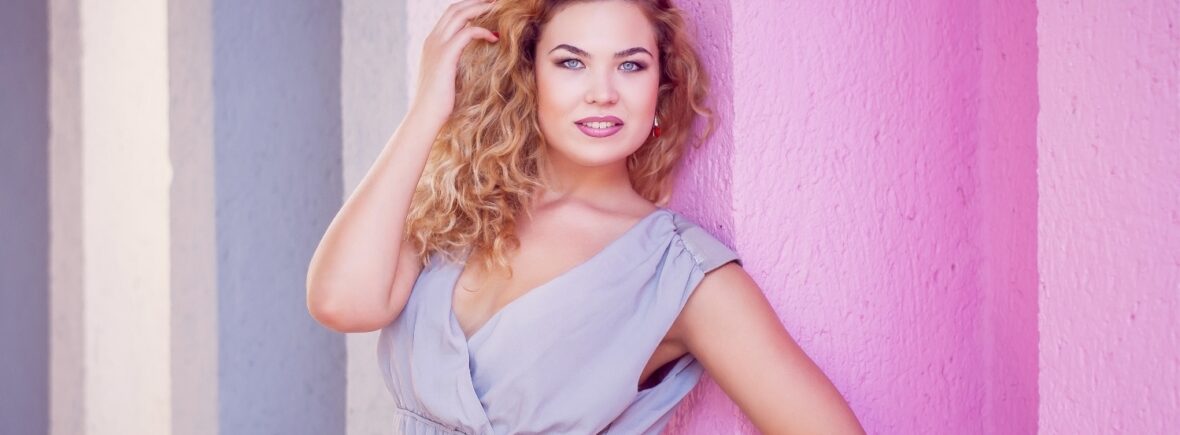 blond girl model plus size on the background of a pink wall